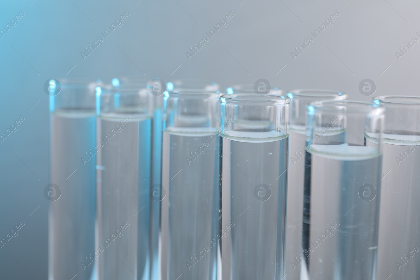 Photo of Laboratory analysis. Test tubes with liquid samples on color background, closeup
