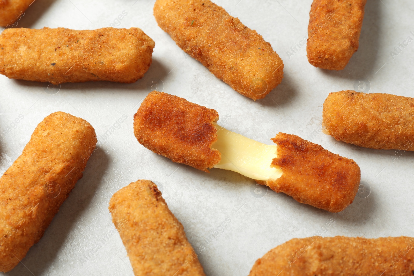 Photo of Tasty cheese sticks on grey background, closeup