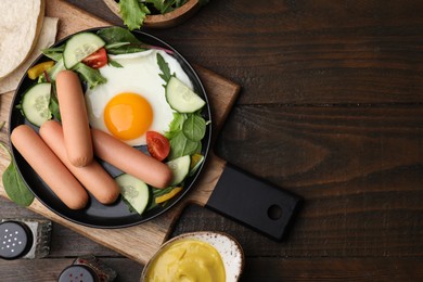 Photo of Delicious breakfast with boiled sausages and fried egg served on wooden table, flat lay. Space for text