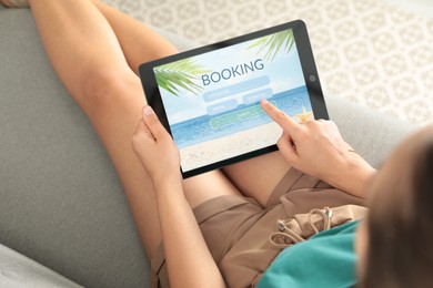 Young woman using tablet to plan trip indoors, closeup. Travel agency concept