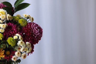 Photo of Bouquet of beautiful chrysanthemum flowers on blurred background, closeup. Space for text