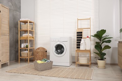 Laundry room interior with washing machine, baskets and houseplant