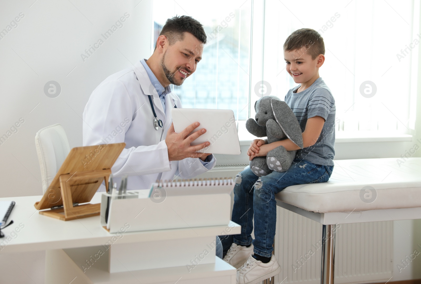 Photo of Children's doctor working with little patient in clinic