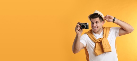 Photo of Male tourist taking picture on yellow background