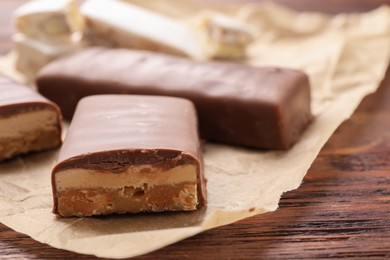 Pieces of tasty chocolate bars with nougat on table, closeup