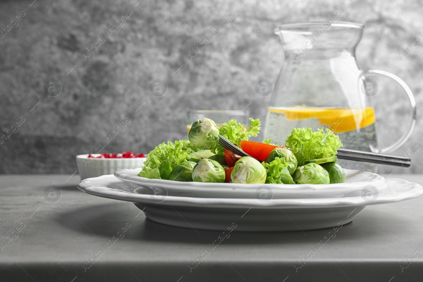 Photo of Tasty salad with Brussels sprouts served on grey table