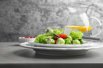 Photo of Tasty salad with Brussels sprouts served on grey table