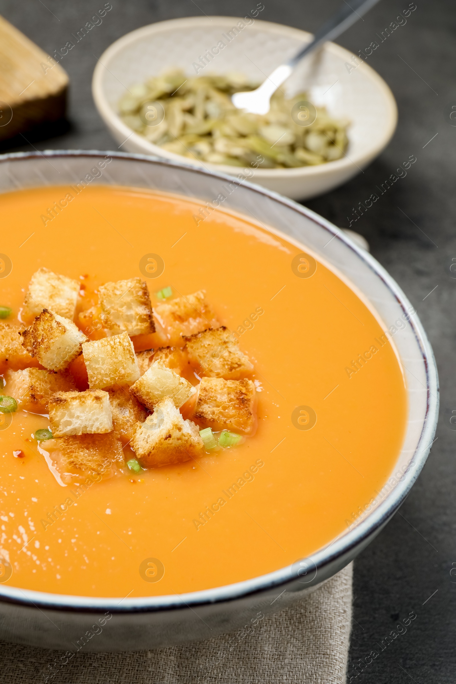 Photo of Tasty creamy pumpkin soup with croutons in bowl on table, closeup