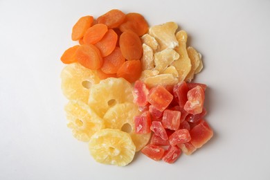 Pile of different dried fruits on white background, top view