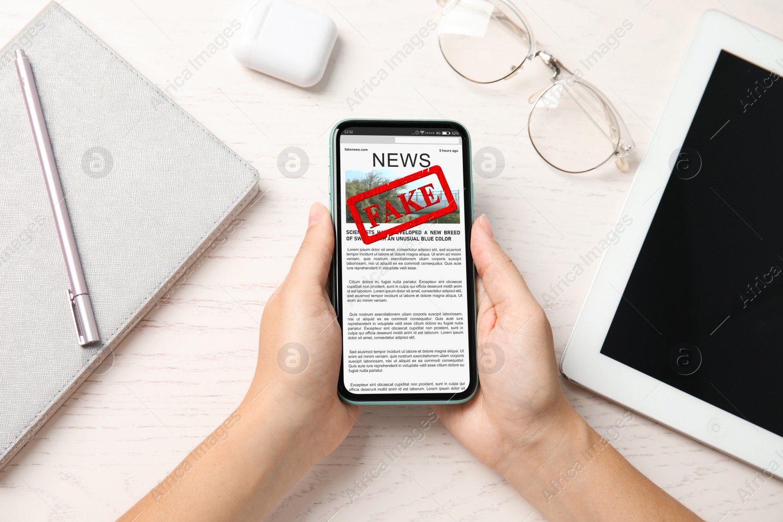 Image of Fake information. Woman using mobile phone to read news at wooden table, closeup. Top view