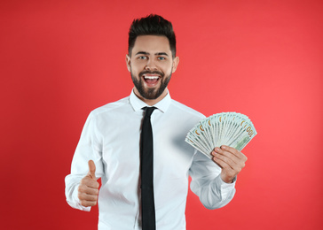 Photo of Emotional young man with money on crimson background