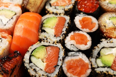 Photo of Different tasty sushi rolls as background, closeup