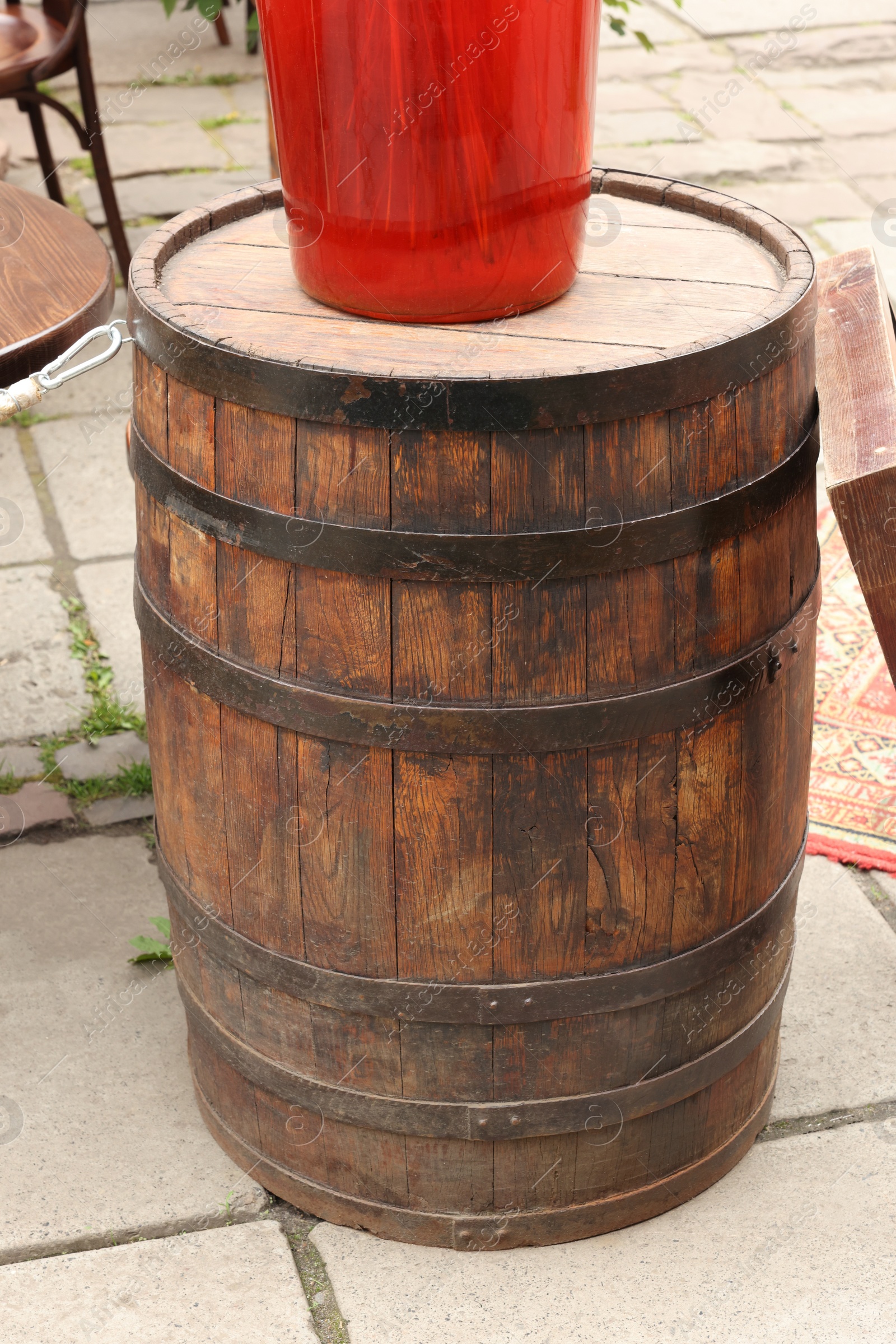 Photo of Traditional wooden barrel on street outdoors. Wine making