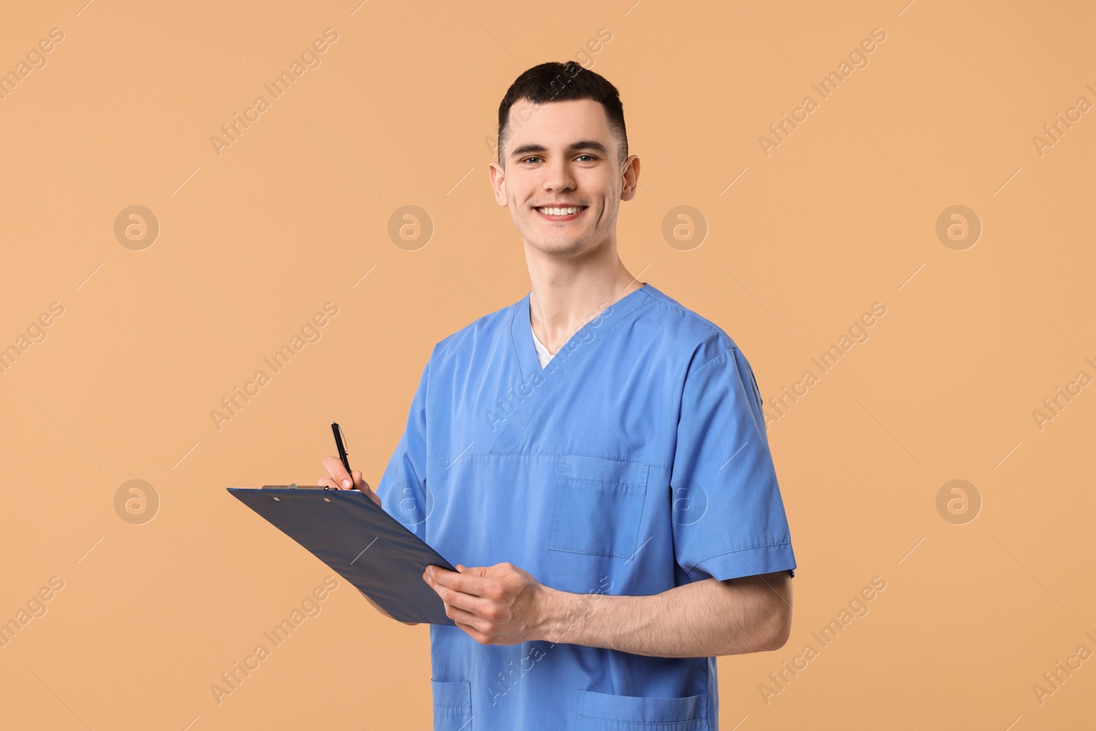 Photo of Portrait of smiling medical assistant with clipboard on beige background