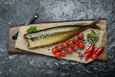 Delicious smoked mackerel and different products on black textured table, top view