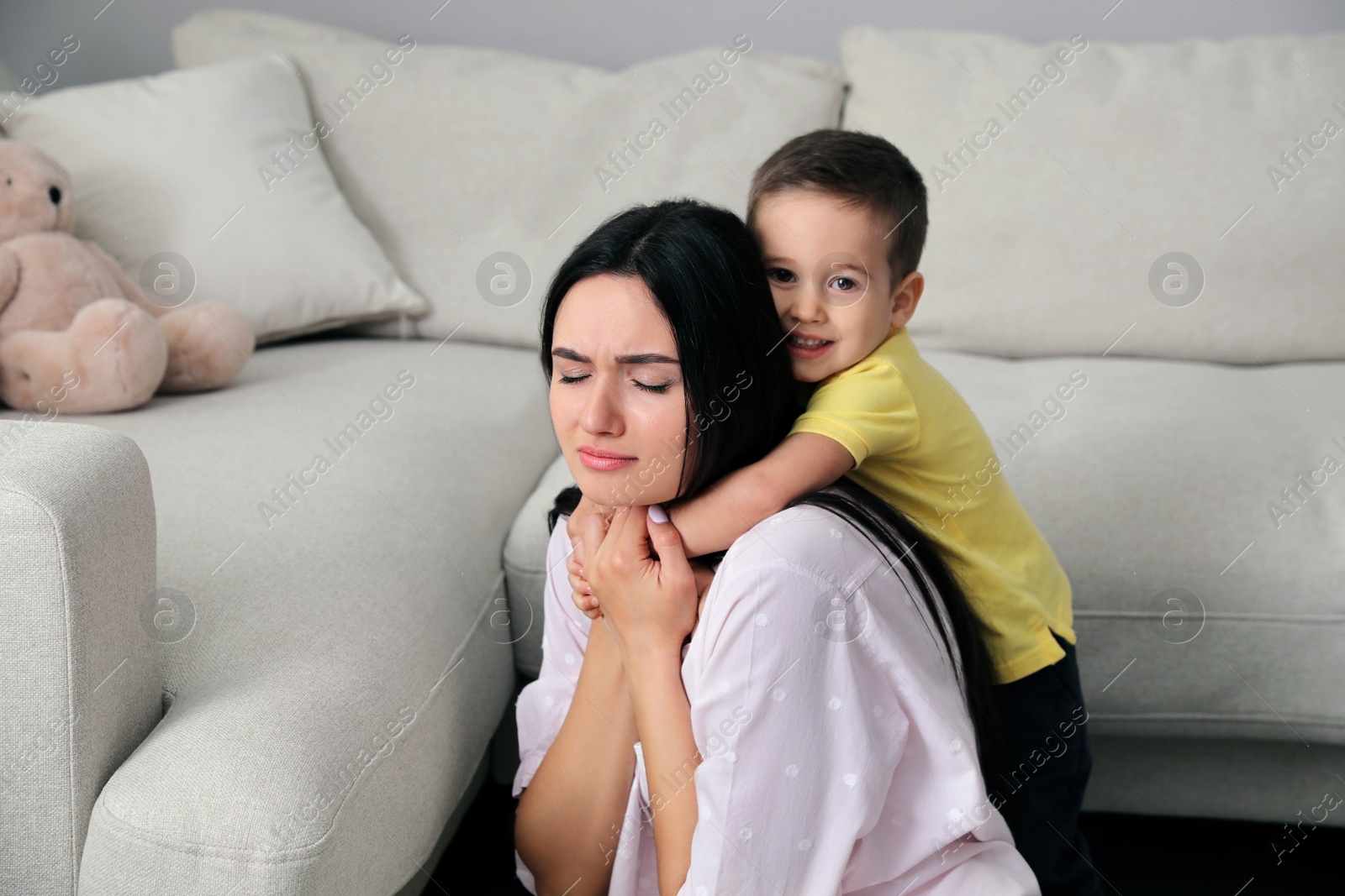 Photo of Depressed single mother with child in living room