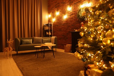 Photo of Beautiful tree with festive lights and Christmas decor in living room. Interior design