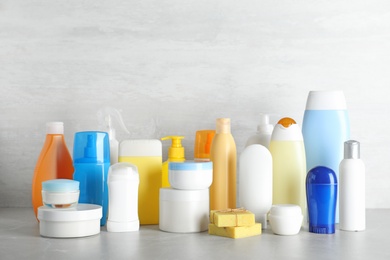 Photo of Different body care products on table against light background