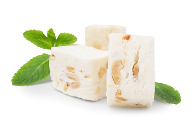 Photo of Pieces of delicious nougat and mint on white background