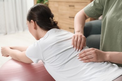 Doula massaging pregnant woman at home. Preparation for child birth