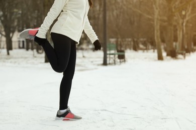 Woman doing sports exercises in winter park, closeup