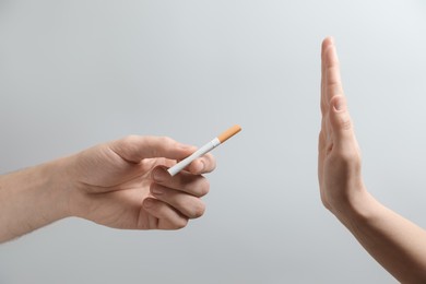 Photo of Man refusing cigarette on grey background, closeup