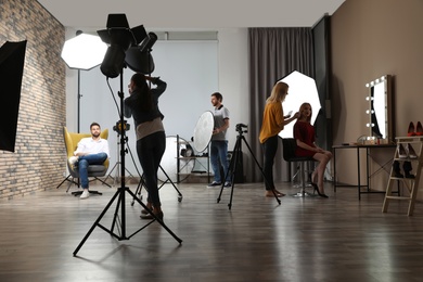 Photo of Photo studio with professional equipment and team of workers