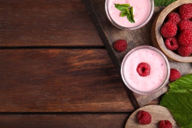 Photo of Tasty fresh raspberry smoothie on wooden table, flat lay. Space for text