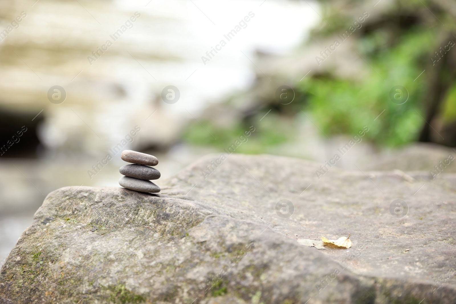 Photo of Balancing zen pebble stones outdoors against blurred background. Space for text