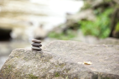 Balancing zen pebble stones outdoors against blurred background. Space for text