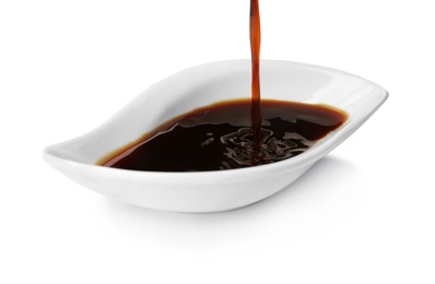 Photo of Pouring tasty soy sauce into bowl isolated on white