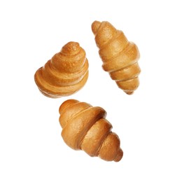 Crusty golden croissants falling on white background