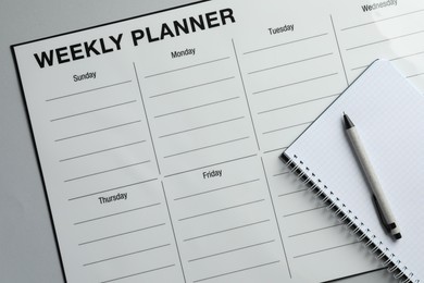 Photo of Timetable. Planner, notebook and pen on grey table, top view