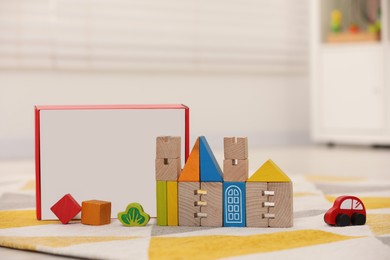 Photo of Set of wooden building blocks on floor indoors. Children's toys