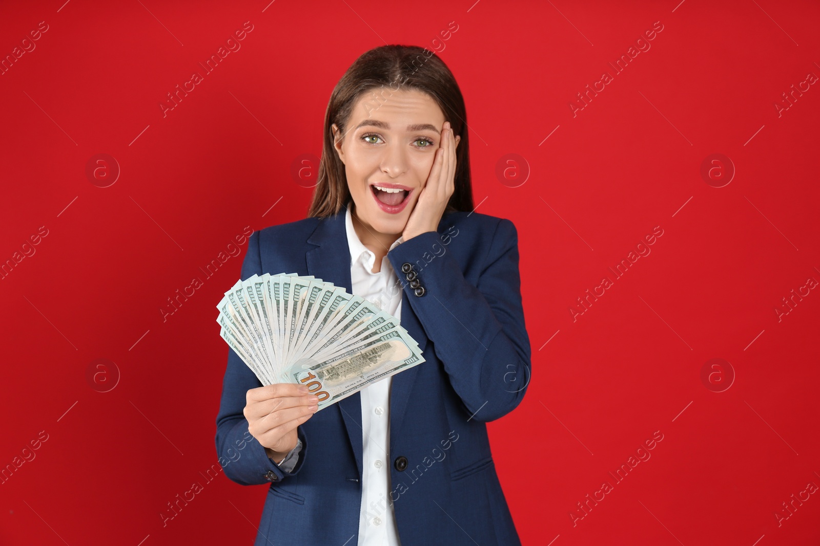 Photo of Emotional young woman with money on crimson background