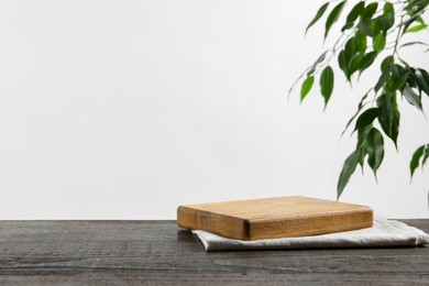 Empty board and towel on wooden table. Space for text