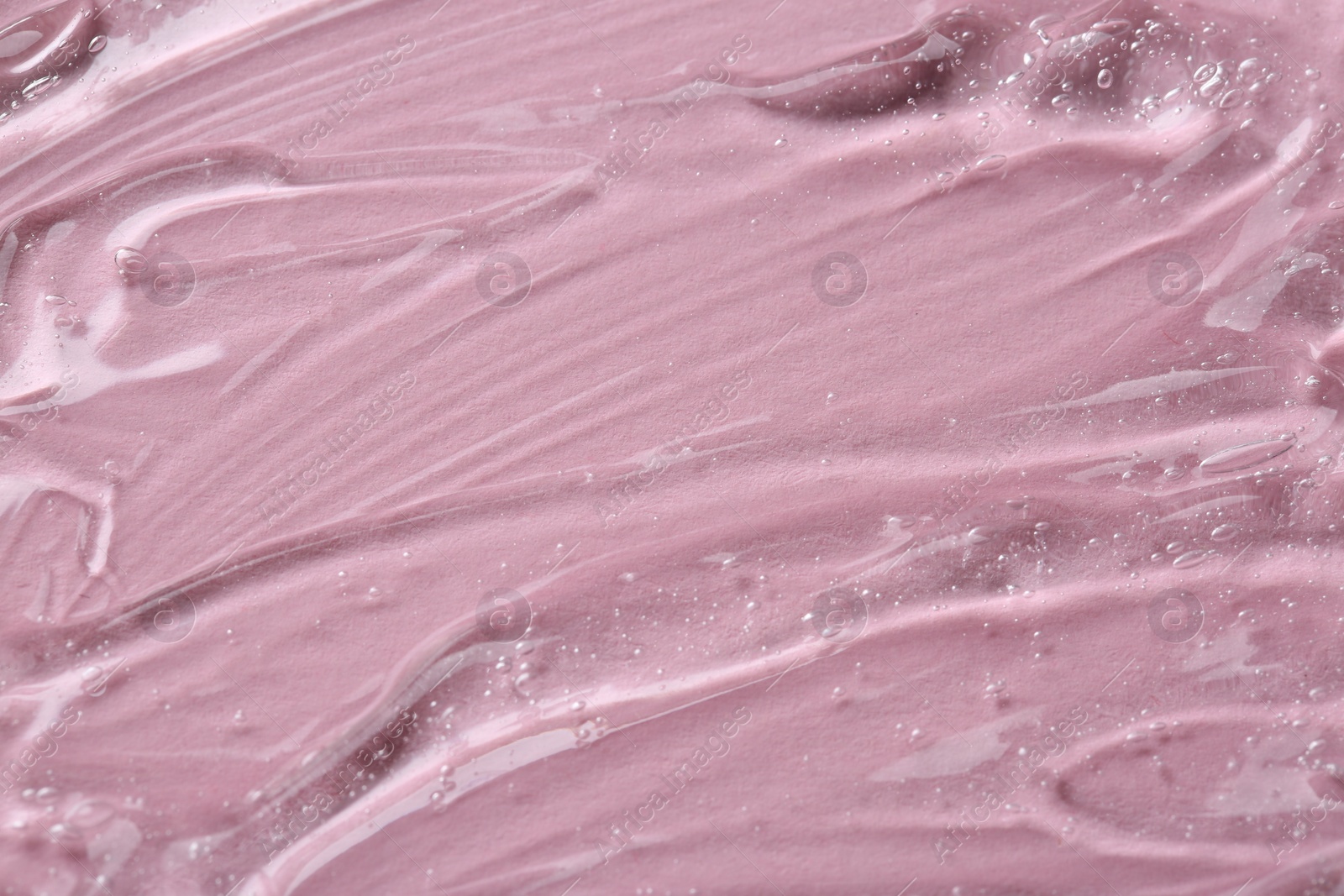 Photo of Clear cosmetic serum on pink background, macro view