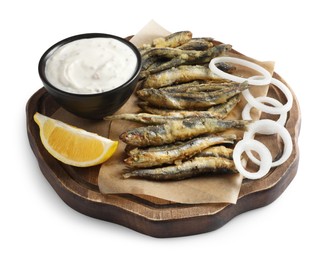 Photo of Board with delicious fried anchovies, onion rings, sauce and slice of lemon isolated on white