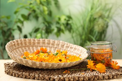 Photo of Many beautiful fresh calendula flowers on table against blurred green background, space for text
