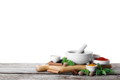 Photo of Mortar and different spices on wooden table against white background. Space for text