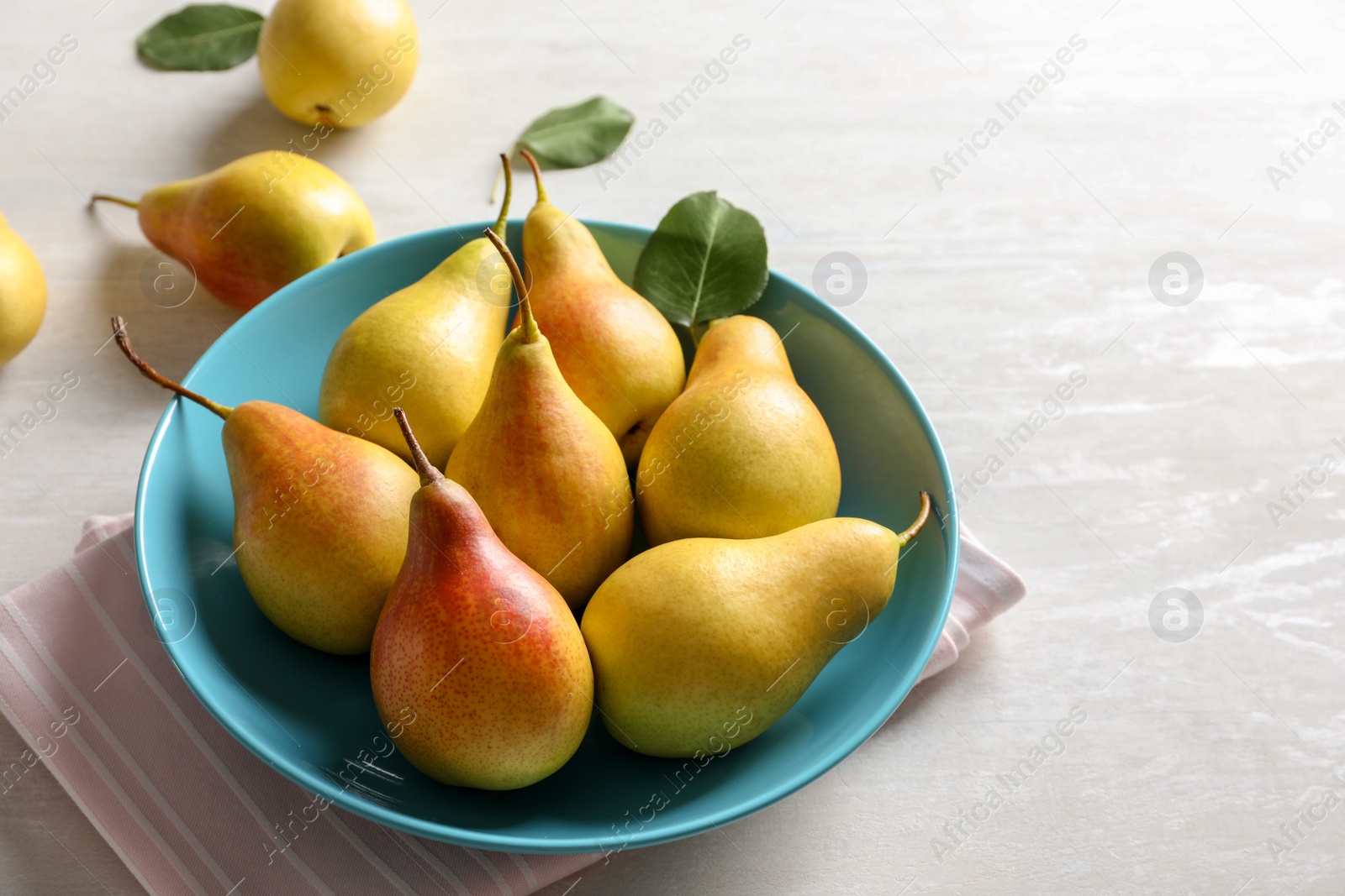 Photo of Plate with ripe pears on light table. Space for text