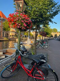Leiden, Netherlands - August 1, 2022: Picturesque view of city canal with moored boats and parked bicycles