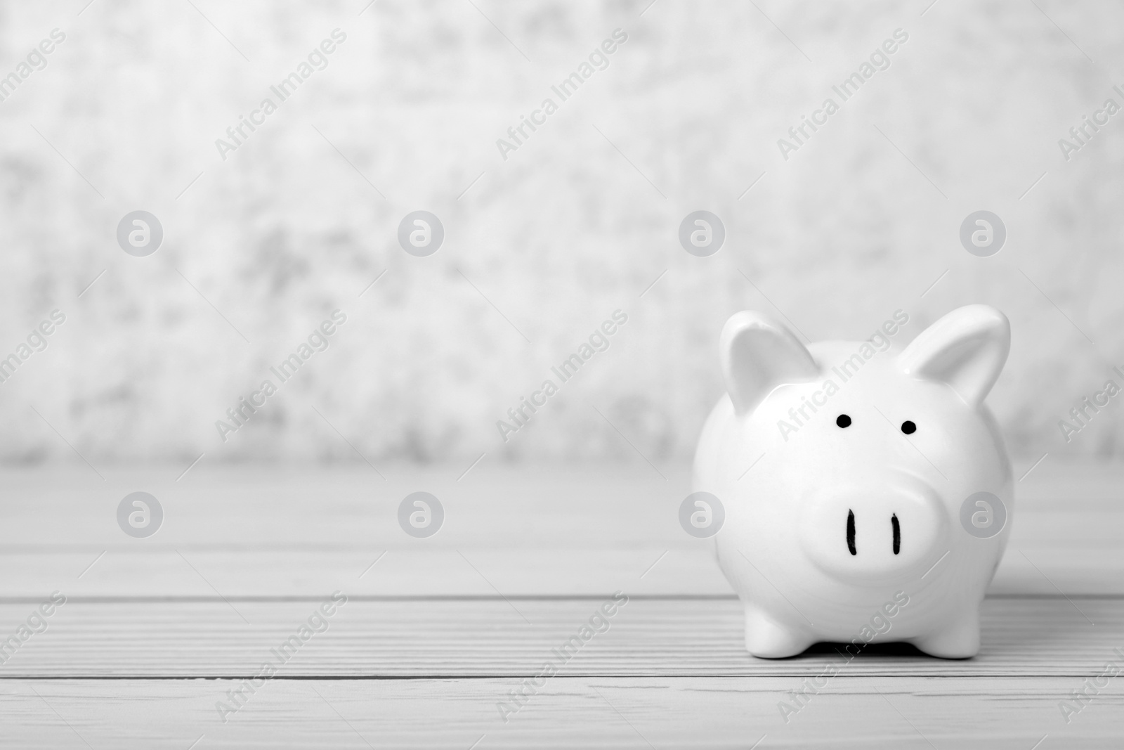 Photo of Ceramic piggy bank on white wooden table, space for text. Financial savings