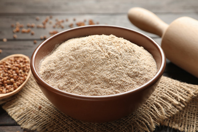 Buckwheat flour in bowl on wooden table