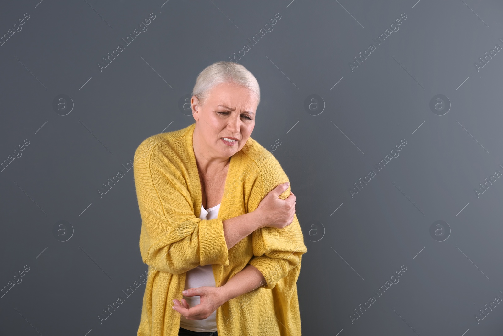 Photo of Mature woman having heart attack on color background