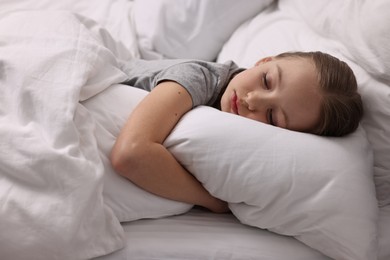 Photo of Little girl suffering from headache in bed