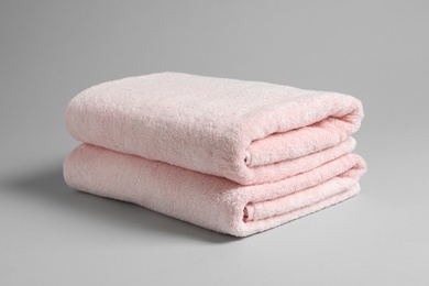 Photo of Fresh soft folded towels on light background