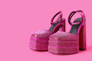 Photo of Fashionable punk square toe ankle strap pumps on pink background, space for text. Shiny party platform high heeled shoes
