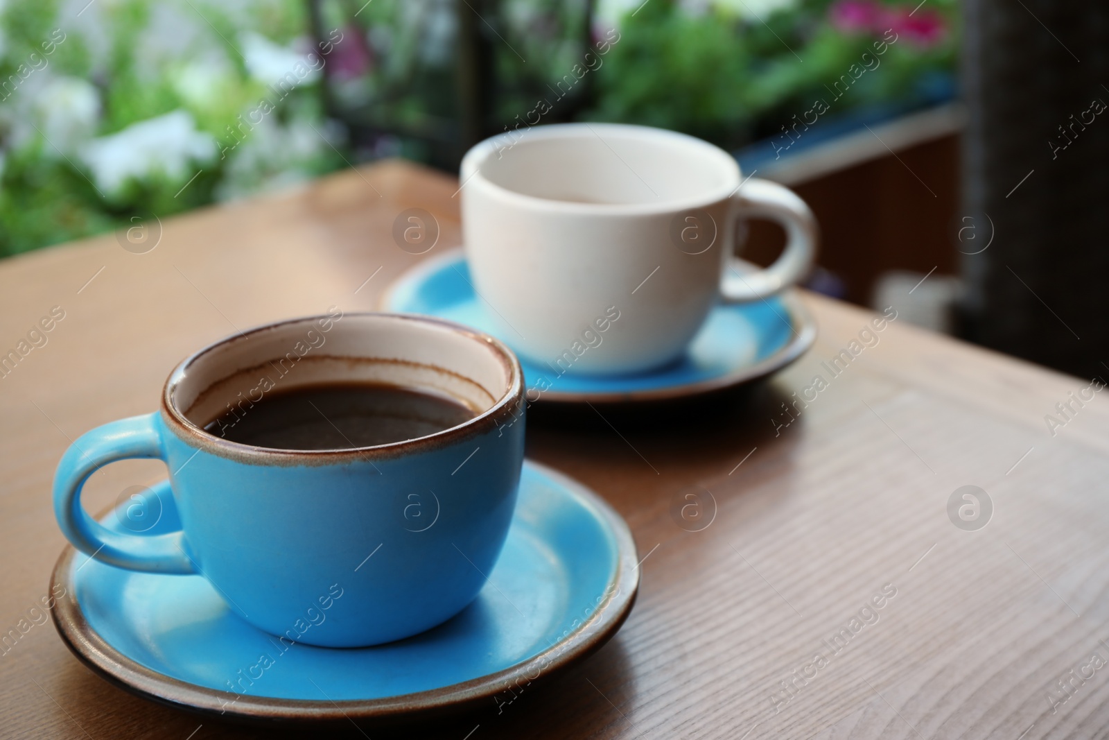 Photo of Cups of fresh aromatic coffee on wooden table