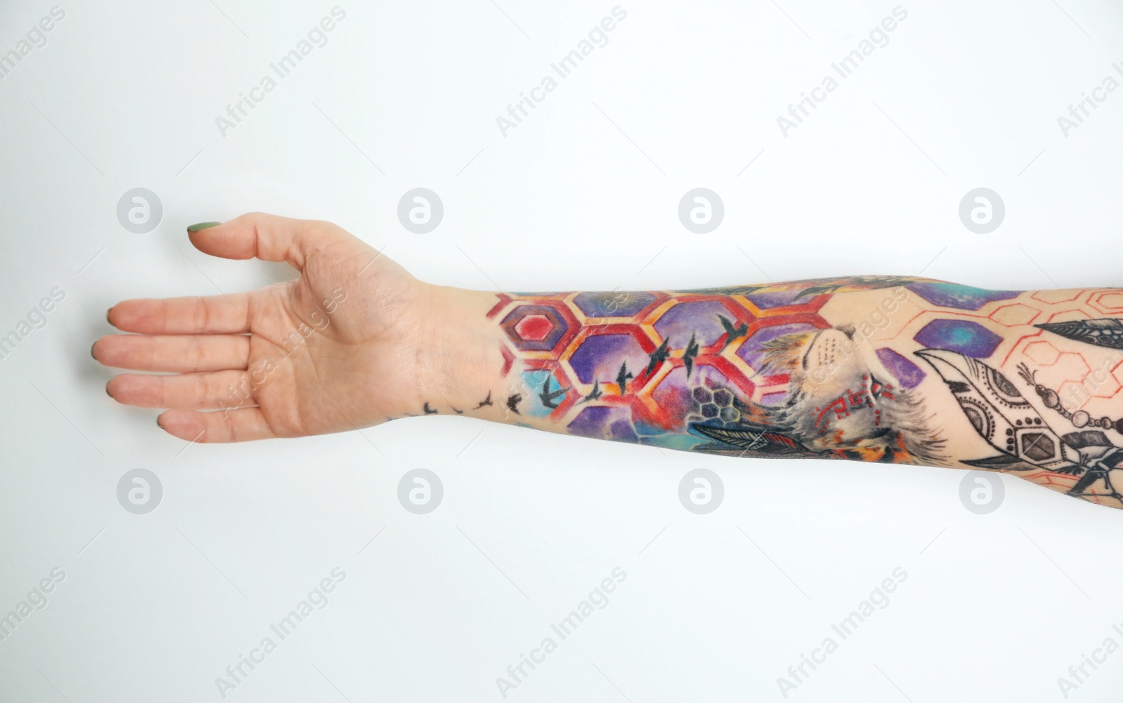 Photo of Woman with colorful tattoos on arm against white background, closeup